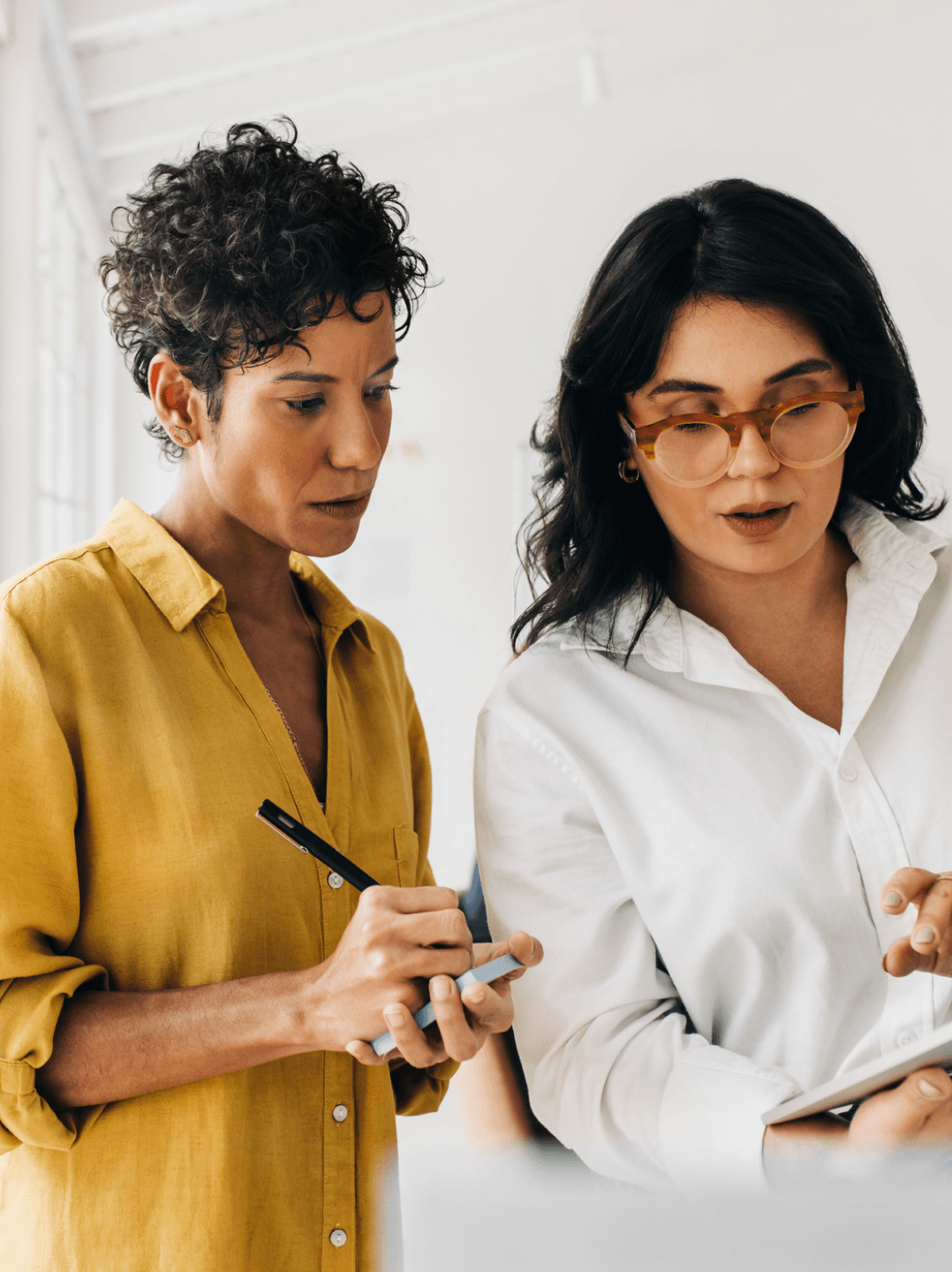 Two women speaking and looking at a laptop
