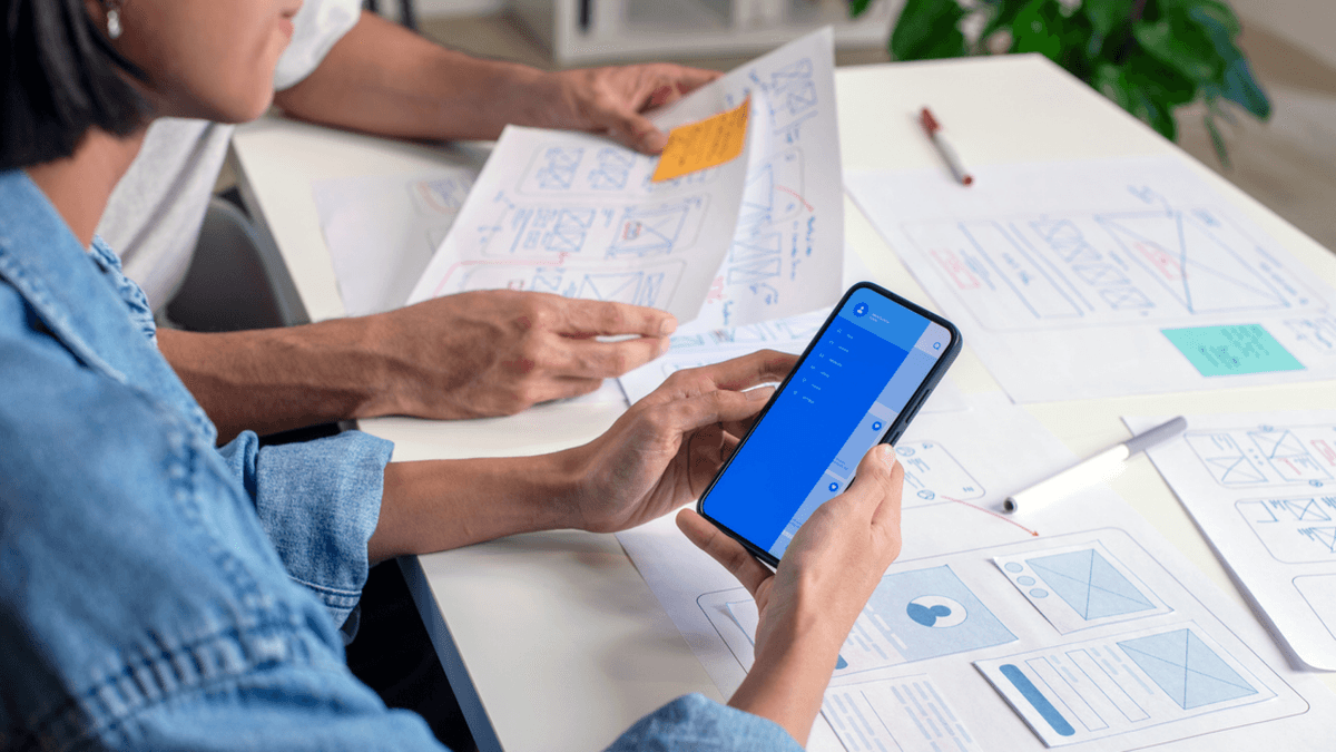 Person using a phone over a table of diagrams